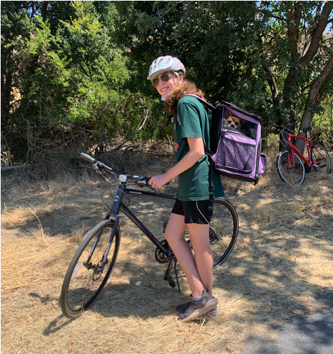 Emily Mitnick with shelter dog by a bicycle taking a break.