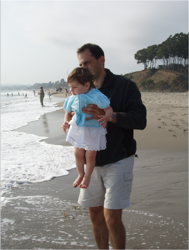 Emily Mitnick smiling while enjoying a sunny day by the ocean, soaking in the waves and light