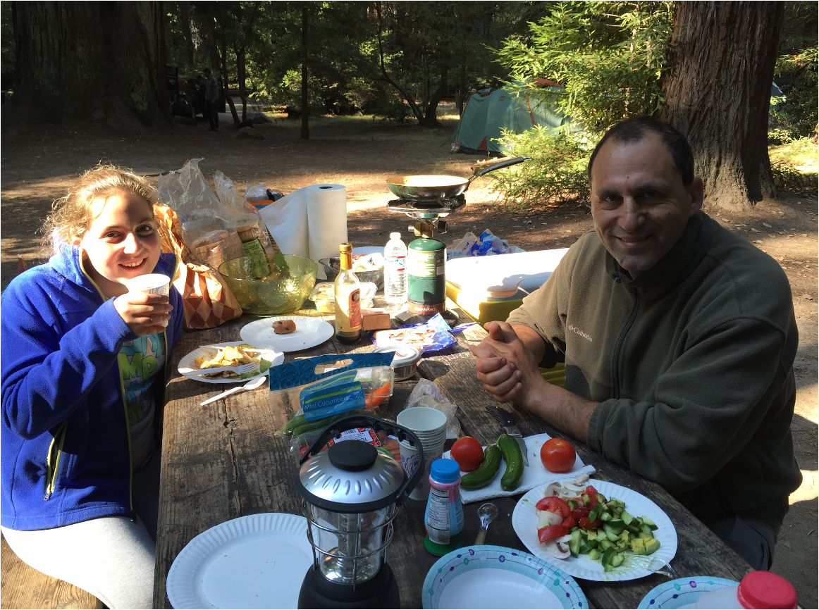 Emily Mitnick enjoying a cozy camping breakfast in a misty, enchanting redwood forest